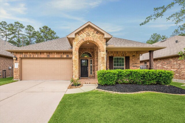 5332 Pointe Spring Xing, Spring, TX 77389 - view of front of property featuring brick siding, roof with shingles, a garage, concrete driveway, and a front yard