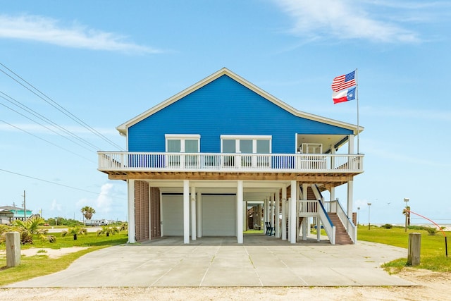998 Austin Dr, Gilchrist, TX 77617 - coastal home featuring a carport, driveway, stairs, a garage, and covered porch