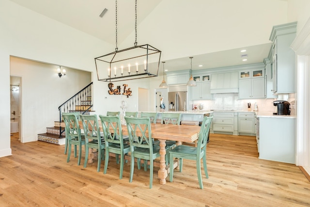 998 Austin Dr, Gilchrist, TX 77617 - dining space featuring light wood-style floors, a towering ceiling, stairway, recessed lighting, and a chandelier
