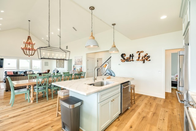 998 Austin Dr, Gilchrist, TX 77617 - kitchen featuring a sink, light wood-style floors, stainless steel appliances, pendant lighting, and high vaulted ceiling