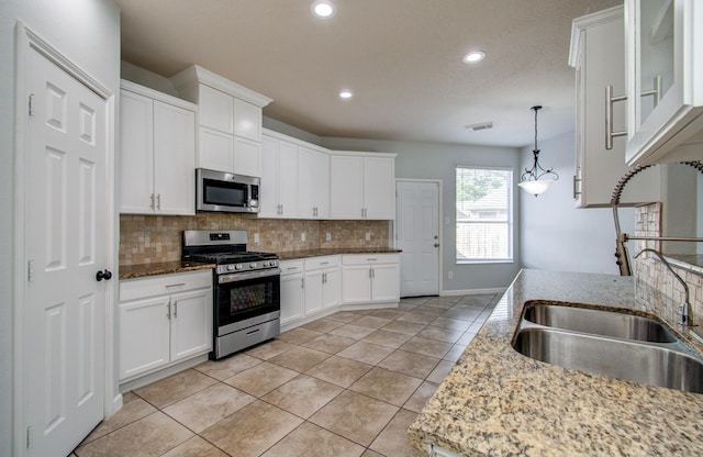 14814 Bridle Bend Dr, Houston, TX 77084 - kitchen featuring appliances with stainless steel finishes, backsplash, light tile patterned floors, recessed lighting, and a sink
