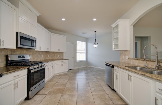 14814 Bridle Bend Dr, Houston, TX 77084 - kitchen featuring appliances with stainless steel finishes, a sink, baseboards, tasteful backsplash, and white cabinets