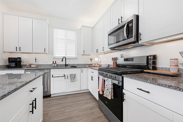 17723 Seed Drill Ln, Hockley, TX 77447 - kitchen with appliances with stainless steel finishes, a sink, decorative backsplash, and white cabinetry