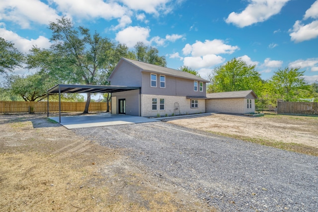 1021 S State St, Madisonville, TX 77864 - rear view of property featuring dirt driveway, an attached carport, and brick siding
