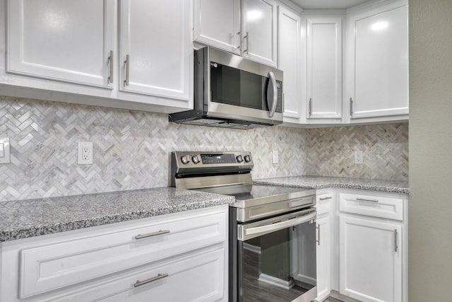 1021 S State St, Madisonville, TX 77864 - kitchen with stainless steel appliances, white cabinets, tasteful backsplash, and light stone countertops