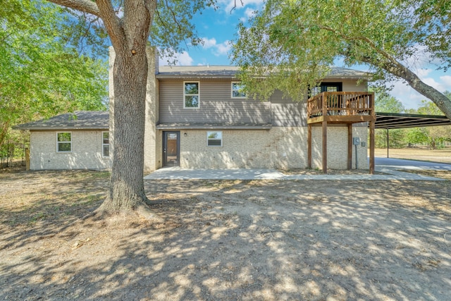 1021 S State St, Madisonville, TX 77864 - rear view of property featuring brick siding, a chimney, and a carport