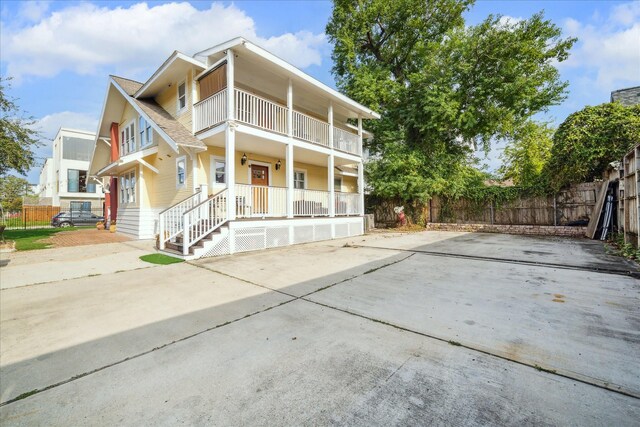 1502 Stuart St, Houston, TX 77004 - view of front of home with a porch, a balcony, fence, and concrete driveway