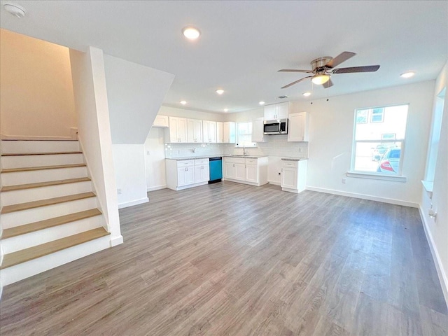 6309 Sandra St, Houston, TX 77028 - unfurnished living room with baseboards, ceiling fan, recessed lighting, light wood-style floors, and stairway