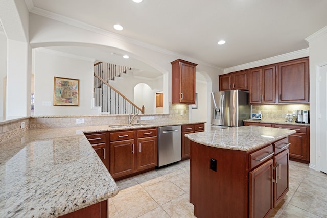 4307 Countrypines Dr, Spring, TX 77388 - kitchen featuring appliances with stainless steel finishes, a sink, arched walkways, light stone countertops, and decorative backsplash