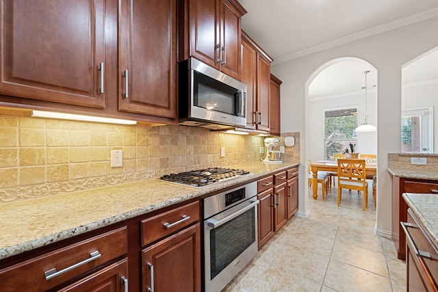 4307 Countrypines Dr, Spring, TX 77388 - kitchen featuring appliances with stainless steel finishes, ornamental molding, tasteful backsplash, light stone counters, and light tile patterned floors