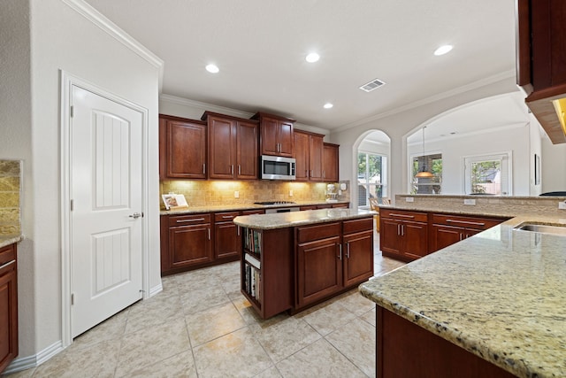 4307 Countrypines Dr, Spring, TX 77388 - kitchen with appliances with stainless steel finishes, arched walkways, backsplash, ornamental molding, and light stone countertops