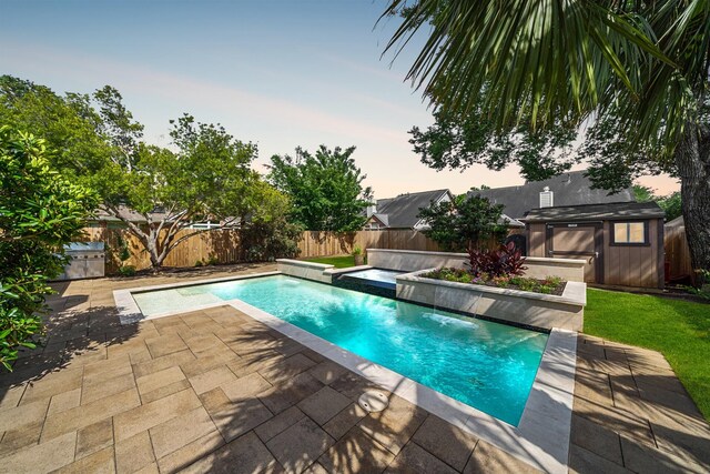 4307 Countrypines Dr, Spring, TX 77388 - pool at dusk featuring a fenced backyard, a patio, an outdoor hot tub, and an outbuilding