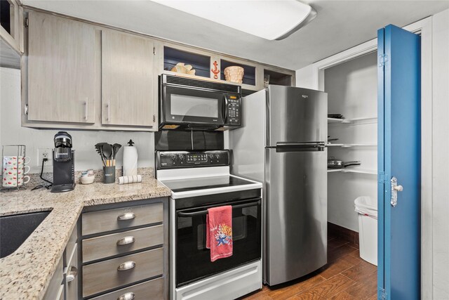 7310 Seawall Blvd Unit 707, Galveston, TX 77551 - kitchen featuring black microwave, electric stove, freestanding refrigerator, dark wood-type flooring, and open shelves