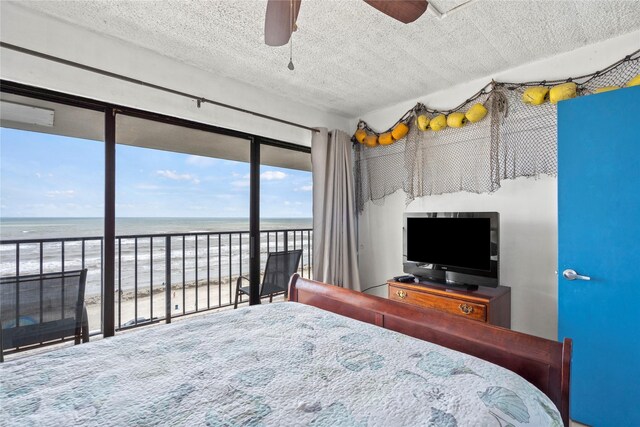 7310 Seawall Blvd Unit 707, Galveston, TX 77551 - bedroom with access to outside, a textured ceiling, a view of the beach, and a ceiling fan