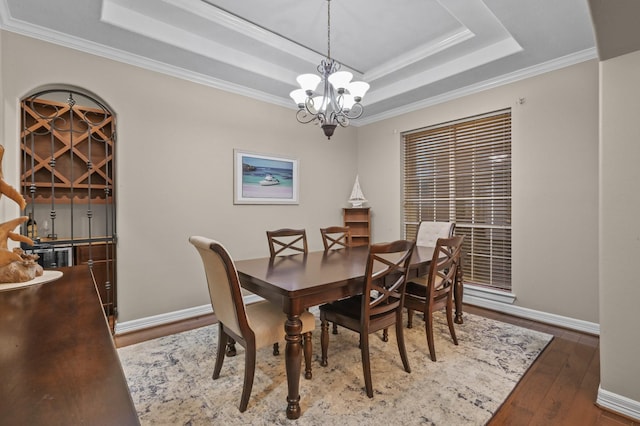 19634 Stone Lake Dr, Tomball, TX 77377 - dining area featuring a tray ceiling, crown molding, wood-type flooring, a chandelier, and baseboards