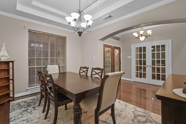 19634 Stone Lake Dr, Tomball, TX 77377 - dining space featuring french doors, a chandelier, arched walkways, wood finished floors, and ornamental molding