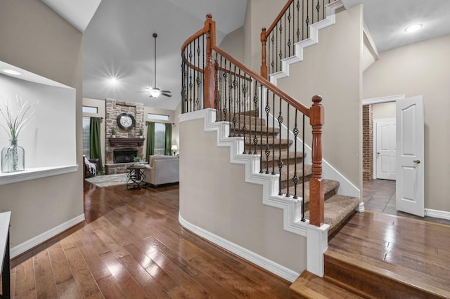 19634 Stone Lake Dr, Tomball, TX 77377 - staircase with a ceiling fan, baseboards, high vaulted ceiling, hardwood / wood-style floors, and a fireplace