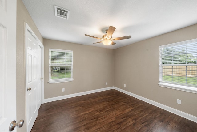 5117 Winding Way, Dickinson, TX 77539 - unfurnished bedroom featuring multiple windows, dark wood-style flooring, and baseboards