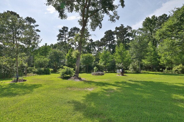 9502 Clubhouse Cir, Magnolia, TX 77354 - view of grassy yard featuring an outdoor fire pit