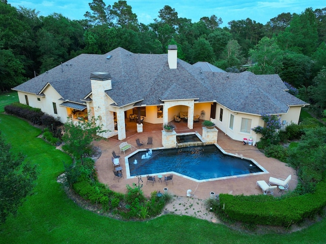 9502 Clubhouse Cir, Magnolia, TX 77354 - rear view of house with a chimney, a patio, a lawn, stone siding, and roof with shingles