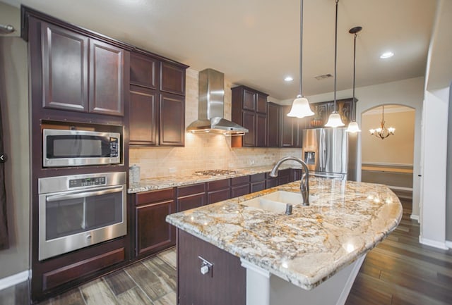 27326 Pendleton Trace Dr, Spring, TX 77386 - kitchen featuring appliances with stainless steel finishes, wall chimney range hood, a sink, backsplash, and dark brown cabinets
