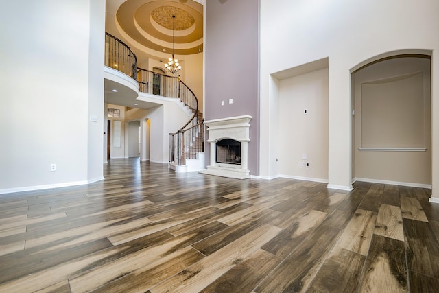27326 Pendleton Trace Dr, Spring, TX 77386 - unfurnished living room with a high ceiling, wood finished floors, a chandelier, and baseboards
