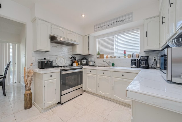 25514 Wingfield Ln, Spring, TX 77373 - kitchen with under cabinet range hood, appliances with stainless steel finishes, light countertops, a sink, and decorative backsplash