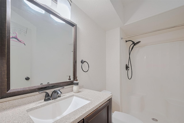 25514 Wingfield Ln, Spring, TX 77373 - bathroom featuring a shower, vanity, toilet, and a textured wall