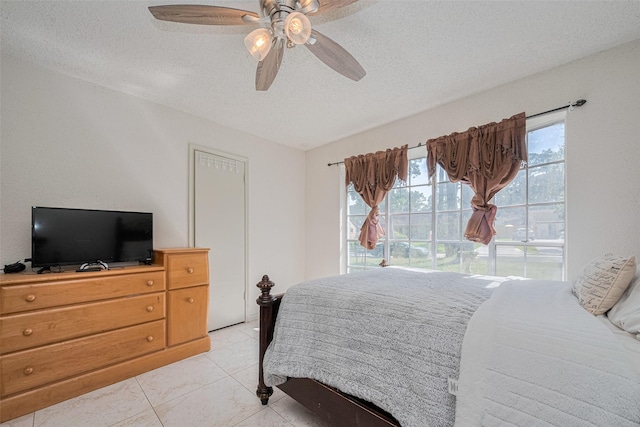 25514 Wingfield Ln, Spring, TX 77373 - bedroom with a textured ceiling, a ceiling fan, and light tile patterned floors