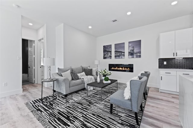7212 England St, Houston, TX 77021 - living area with light wood-style floors, a glass covered fireplace, baseboards, and recessed lighting