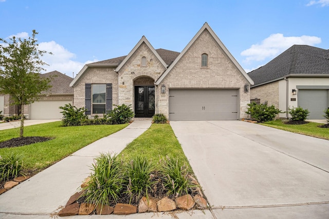 9311 Crescent Mill Dr, Missouri City, TX 77459 - french provincial home with brick siding, concrete driveway, a front lawn, a garage, and roof with shingles