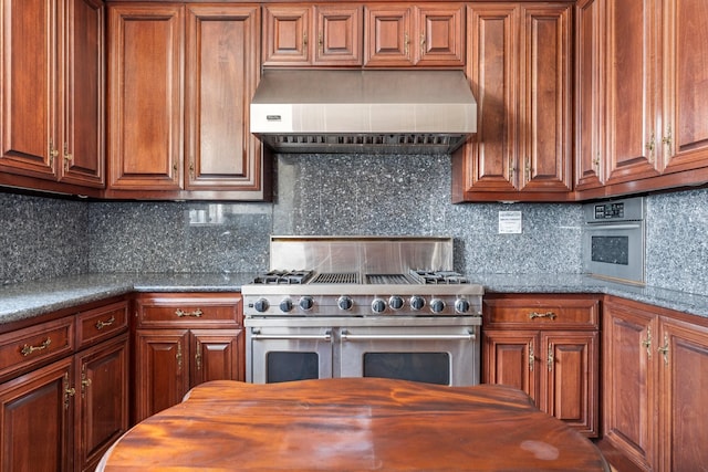 1700 Main St Unit 7B, Houston, TX 77002 - kitchen with wall chimney range hood, range with two ovens, wooden counters, decorative backsplash, and brown cabinetry