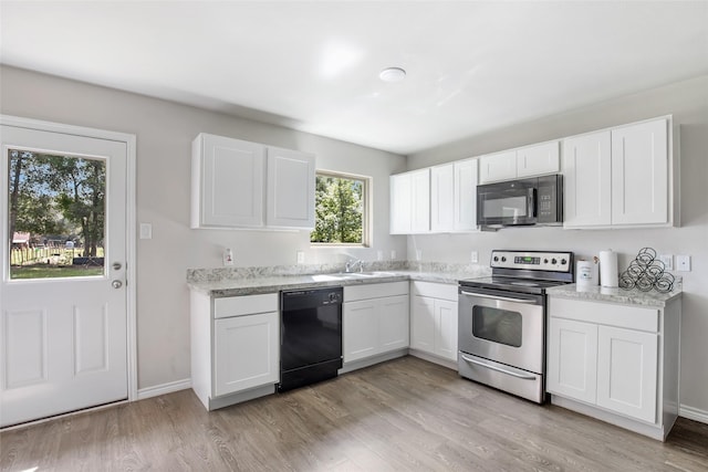 11260 Hodge Rd, Beaumont, TX 77713 - kitchen with black appliances, a sink, white cabinets, and light wood-type flooring