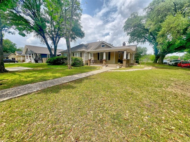 3704 5th St, Brookshire, TX 77423 - view of front of house with a porch, a front yard, and a chimney