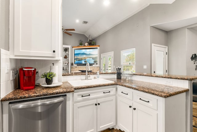 12596 Point Aquarius Blvd, Willis, TX 77318 - kitchen featuring dishwasher, a sink, vaulted ceiling, a peninsula, and tasteful backsplash