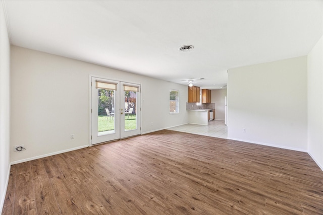 9547 Beverlyhill St, Houston, TX 77063 - unfurnished living room with light wood finished floors, baseboards, french doors, and ceiling fan