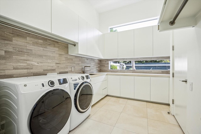 311 Brown Saddle St, Houston, TX 77057 - laundry area with separate washer and dryer, light tile patterned floors, and cabinet space