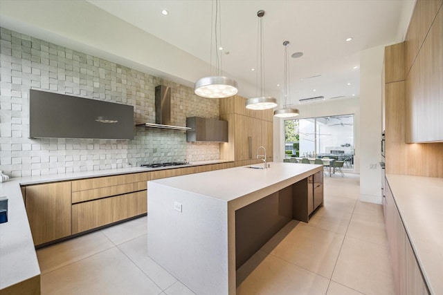 311 Brown Saddle St, Houston, TX 77057 - kitchen with modern cabinets, light countertops, wall chimney exhaust hood, an island with sink, and light tile patterned floors
