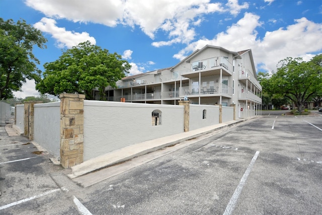 730 E Mather St Unit J-301, New Braunfels, TX 78130 - view of building exterior featuring uncovered parking and fence