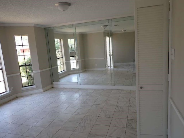 5407 Victoria Dr, Rosharon, TX 77583 - empty room featuring baseboards, a textured ceiling, and ornamental molding