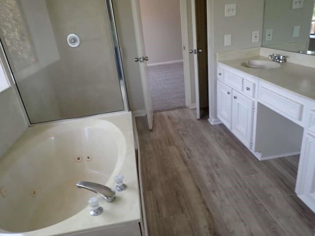 5407 Victoria Dr, Rosharon, TX 77583 - full bathroom with a tub with jets, vanity, and wood finished floors