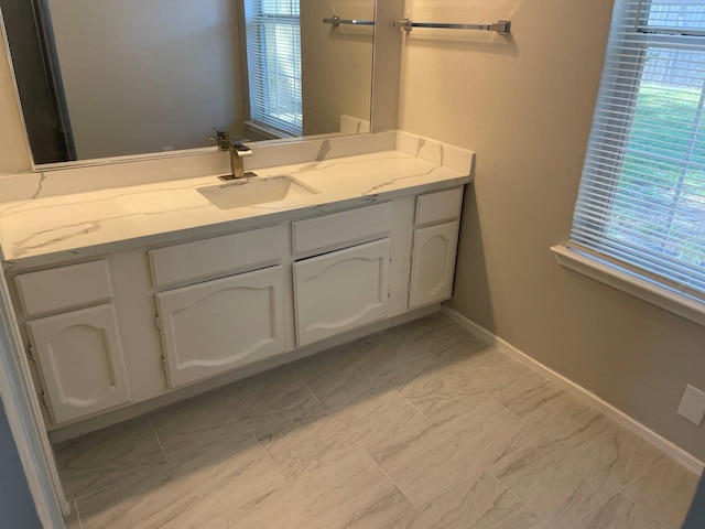 8315 Marble Arch Ct, Humble, TX 77338 - bathroom featuring vanity, plenty of natural light, baseboards, and marble look tile flooring