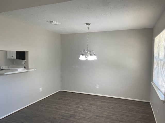 8315 Marble Arch Ct, Humble, TX 77338 - unfurnished dining area with dark wood-type flooring, a chandelier, baseboards, and a textured ceiling