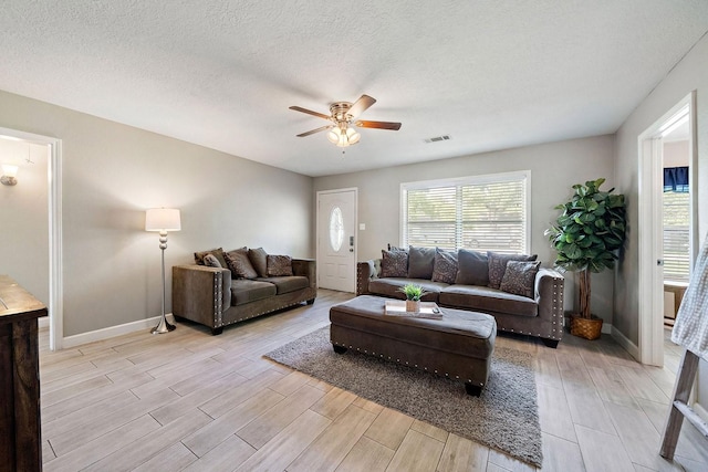 715 S Nugent St, La Porte, TX 77571 - living area with a ceiling fan, light wood finished floors, plenty of natural light, baseboards, and a textured ceiling