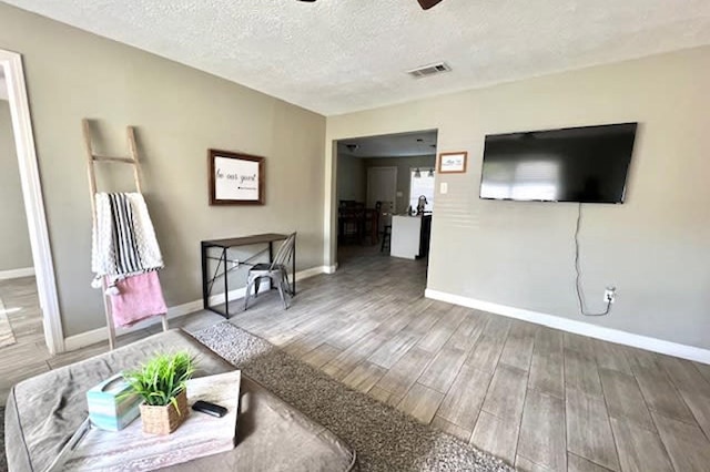 715 S Nugent St, La Porte, TX 77571 - living room featuring ceiling fan, baseboards, wood finished floors, and a textured ceiling