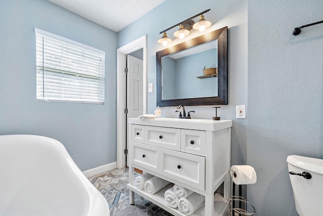 715 S Nugent St, La Porte, TX 77571 - bathroom featuring a freestanding bath, vanity, toilet, and baseboards