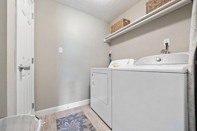 715 S Nugent St, La Porte, TX 77571 - clothes washing area featuring independent washer and dryer, light wood-type flooring, baseboards, and a textured ceiling