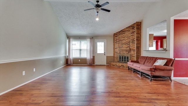 23938 Spring Way Dr, Spring, TX 77373 - living area featuring lofted ceiling, a ceiling fan, a textured ceiling, wood finished floors, and a fireplace