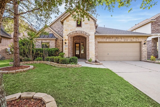 7930 Rippling Stream Ln, Richmond, TX 77407 - french country home with driveway, a garage, a front lawn, brick siding, and roof with shingles