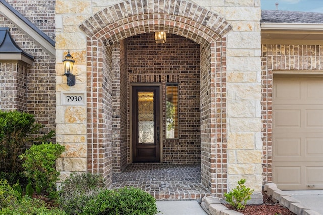 7930 Rippling Stream Ln, Richmond, TX 77407 - view of exterior entry with brick siding, stone siding, and a garage